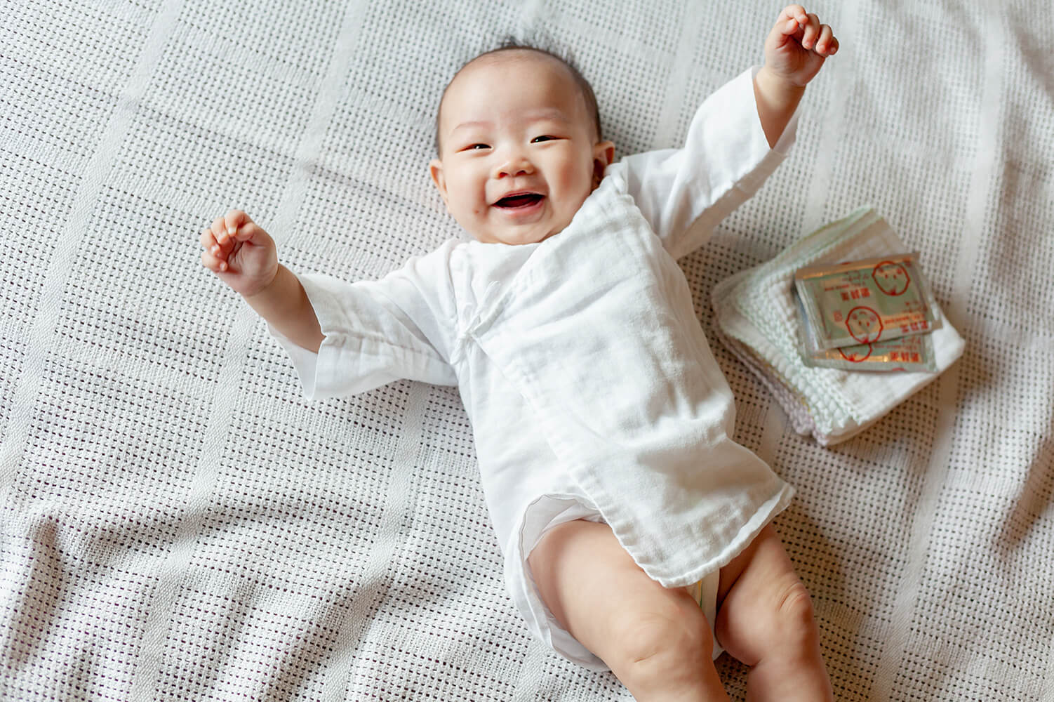 Happy baby wearing Suzuran Baby Gauze Short Undershirt with Gauze Handkerchief and Wet Cleaning Cotton (baby oral wipes).